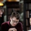 Students reading book in library