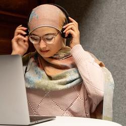 A woman putting on headphones ready to watch a webinar