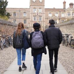 Three students walk down the lane leading to Jesus College