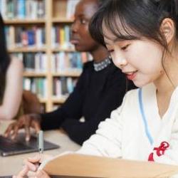 Group of students using laptops in a library