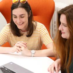 Two students watching a laptop screen