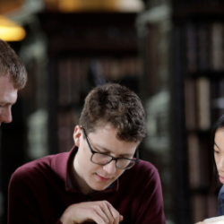 Students reading book in library